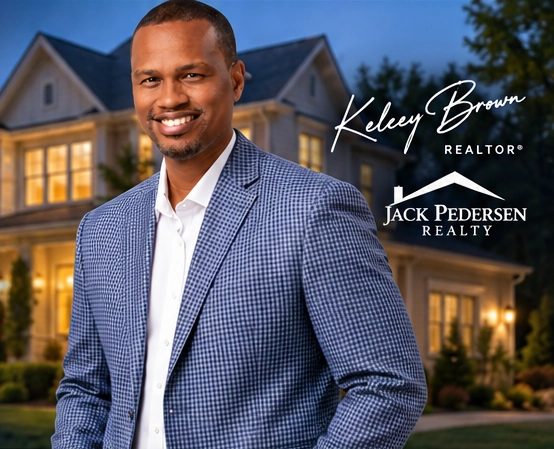 Kelcey Brown in the blue checked blazer from the approved website rendering, against a house at dusk